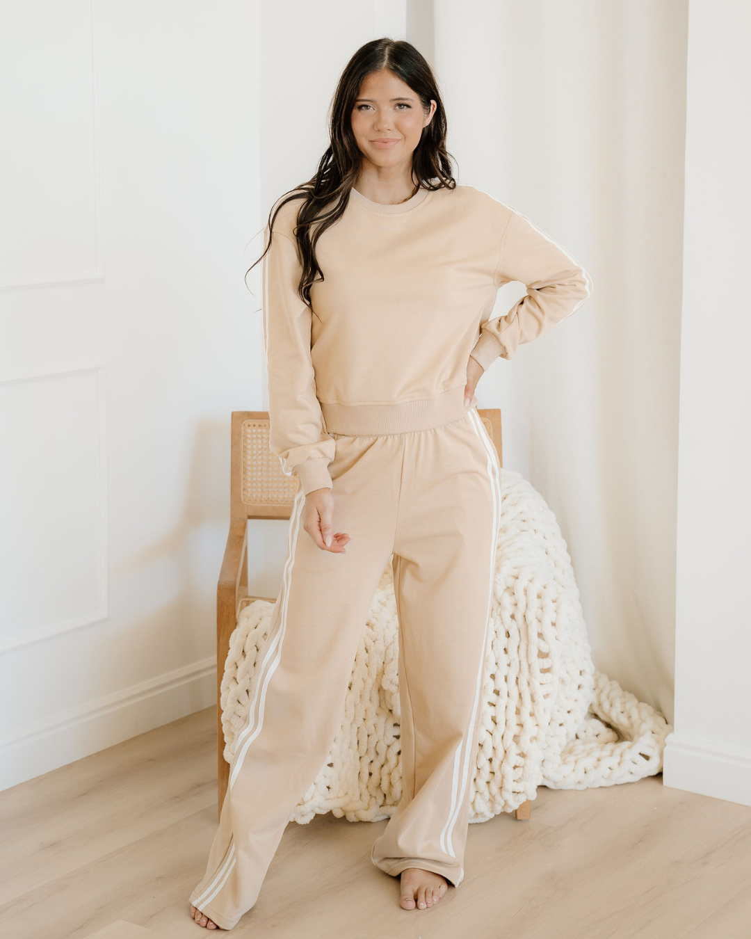 Front view of a two-piece women's lounge set featuring an oatmeal-colored varsity pullover sweatshirt and matching loose, wide-leg pants.