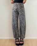 Front view of the Naeve high-waist barrel leg jeans featuring a bold, all-over leopard print pattern, structured front pockets, and a relaxed, tapered leg silhouette.