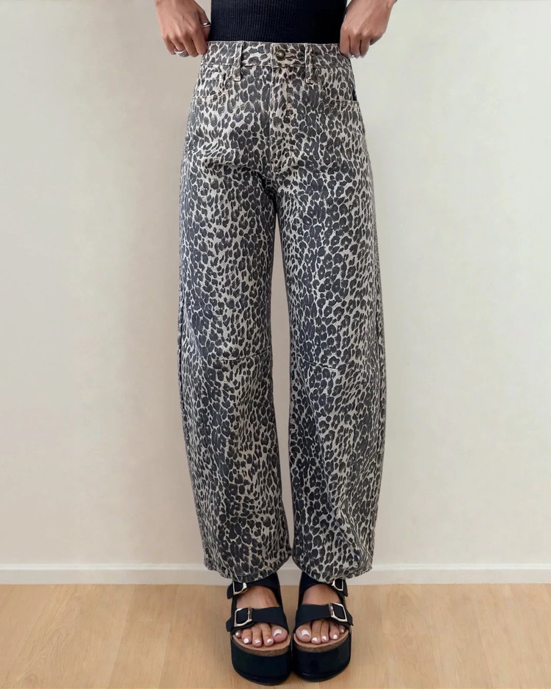 Front view of the Naeve high-waist barrel leg jeans featuring a bold, all-over leopard print pattern, structured front pockets, and a relaxed, tapered leg silhouette.
