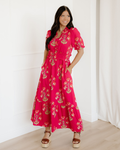 Women's pink floral print maxi dress featuring short sleeves, a frilled V-neckline with a ruffle collar, and an elasticized ruffle-trimmed wide waistband.