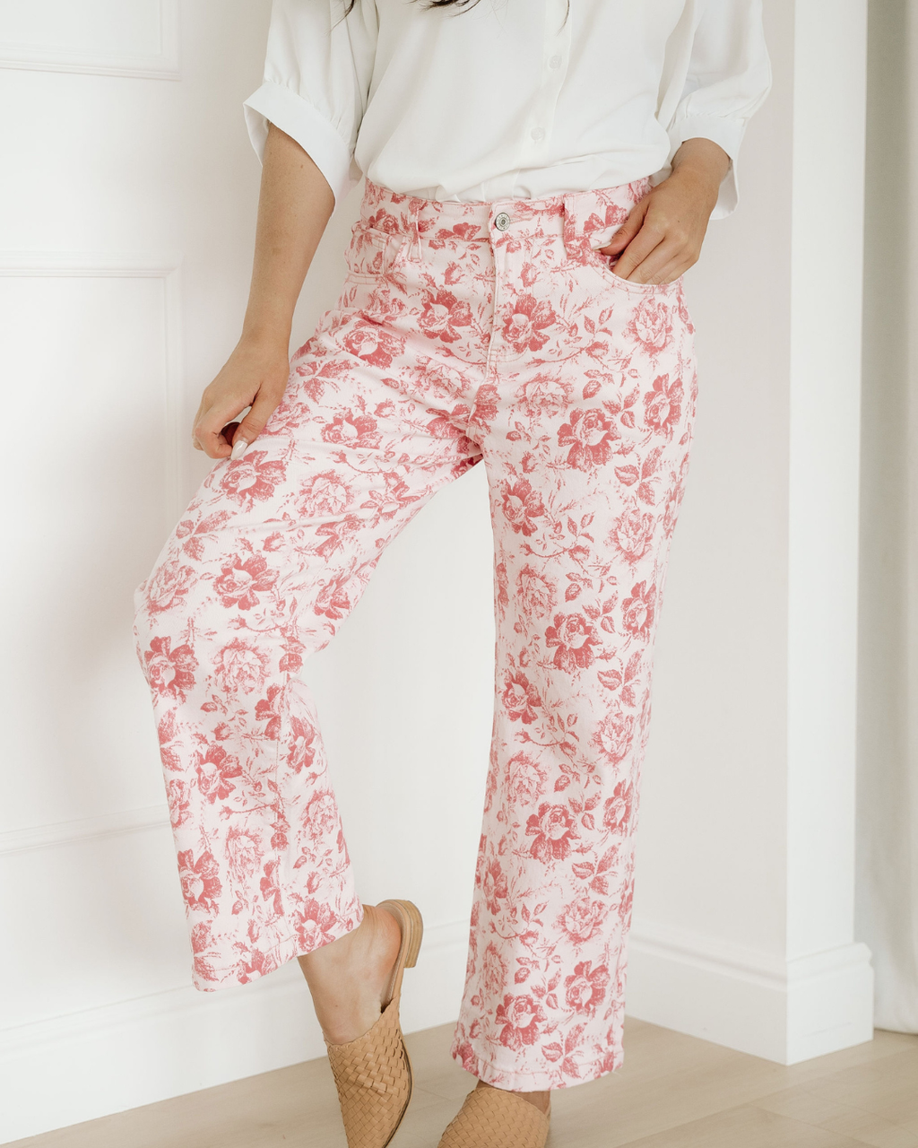Front view of women's ankle-length denim shift pants featuring a pink vintage floral print, button fly closure, and practical side pockets.