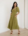 Women's green polka dot maxi dress featuring a vintage-inspired lacy neckline, a smocked high-waisted bodice, and a flowy long tiered skirt layout.