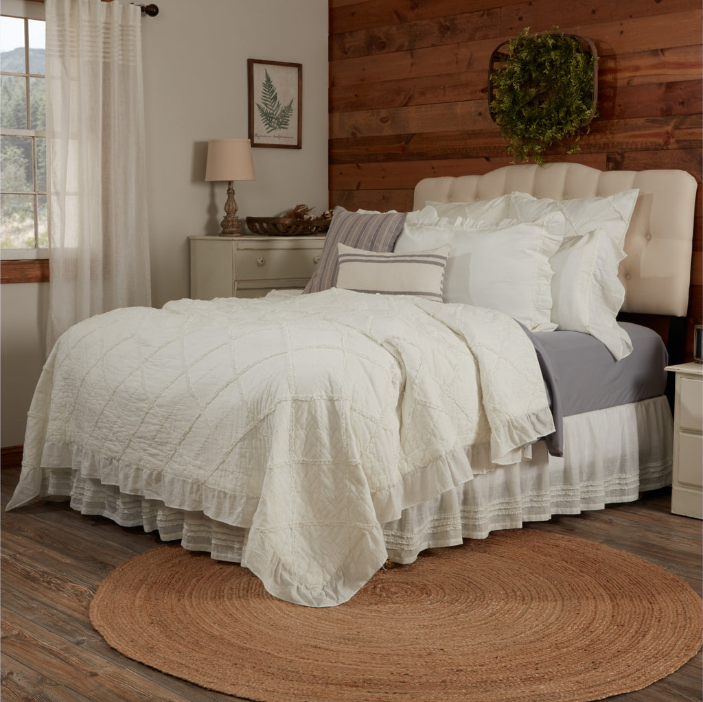Kathryn King Quilt in cream white with tiered ruffle edges on a bed.