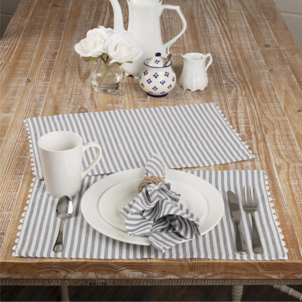 Set of four 18x18 cotton cloth napkins in a denim blue and antique white farmhouse ticking stripe pattern.
