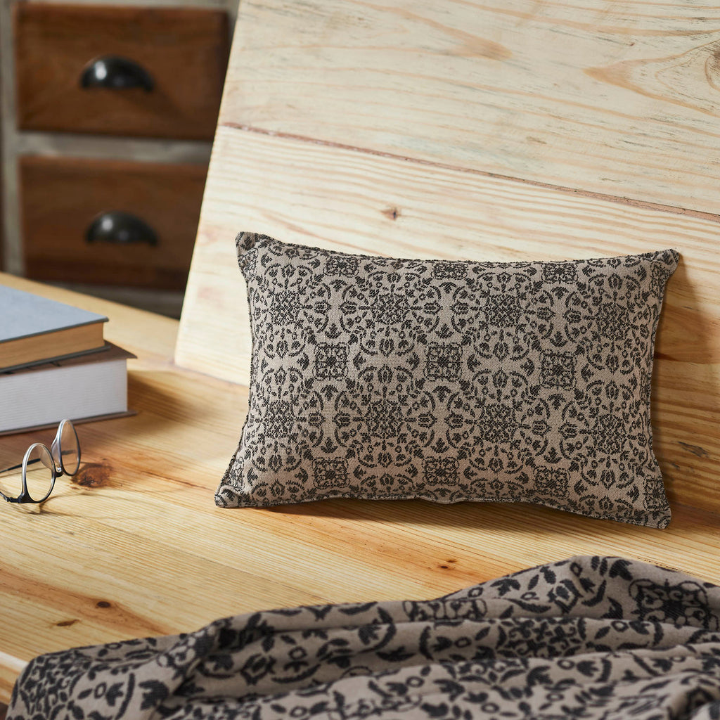 Black and tan jacquard lumbar accent pillow featuring a woven floral pattern measuring 9.5 x 14 inches.
