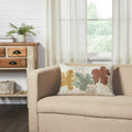 Bountiful Leaves embroidered throw pillow displayed on a neutral beige armchair in a cozy living room setting.
