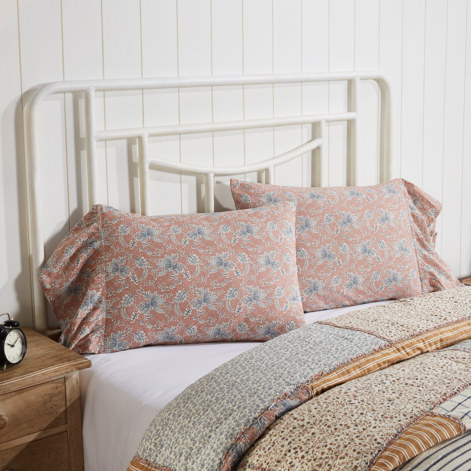 Set of two dusty rose country pillowcases featuring a navy and creme floral pattern with an elegant 8-inch ruffle trim.