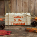 Rustic faux wooden book stack with the phrase "Gather & Be Thankful," distressed white finish, and jute twine measuring 6 x 4 x 2.5 inches.