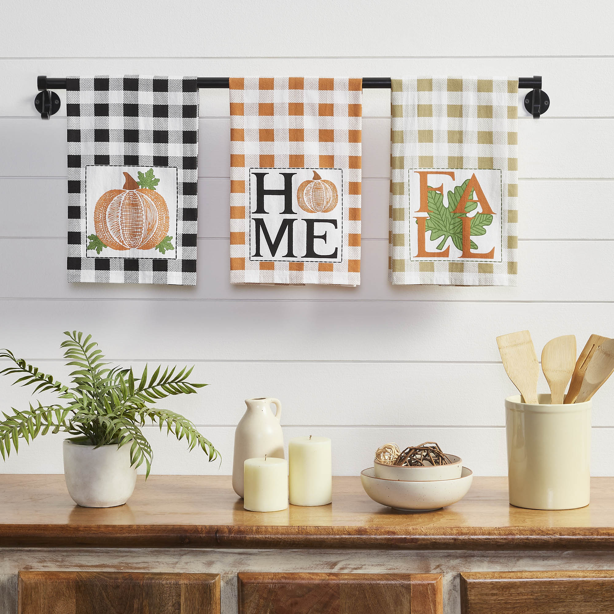 Set of three farmhouse fall kitchen towels featuring buffalo check patterns with pumpkin, HOME, and FALL designs on 100% cotton muslin fabric.