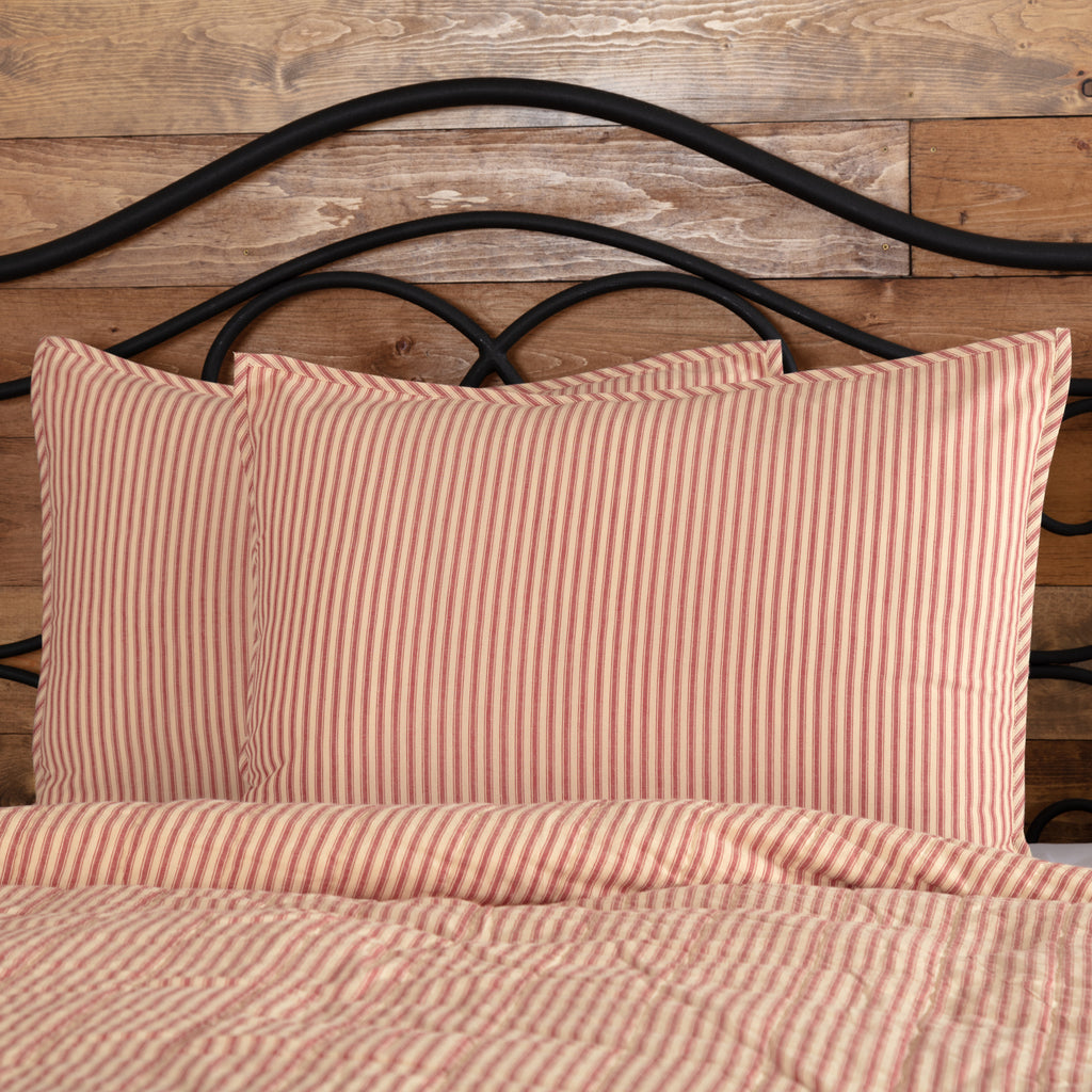 Wide shot of a Twin bed featuring the Sawyer Mill Red Ticking Stripe Quilt Coverlet in a rustic farmhouse room.