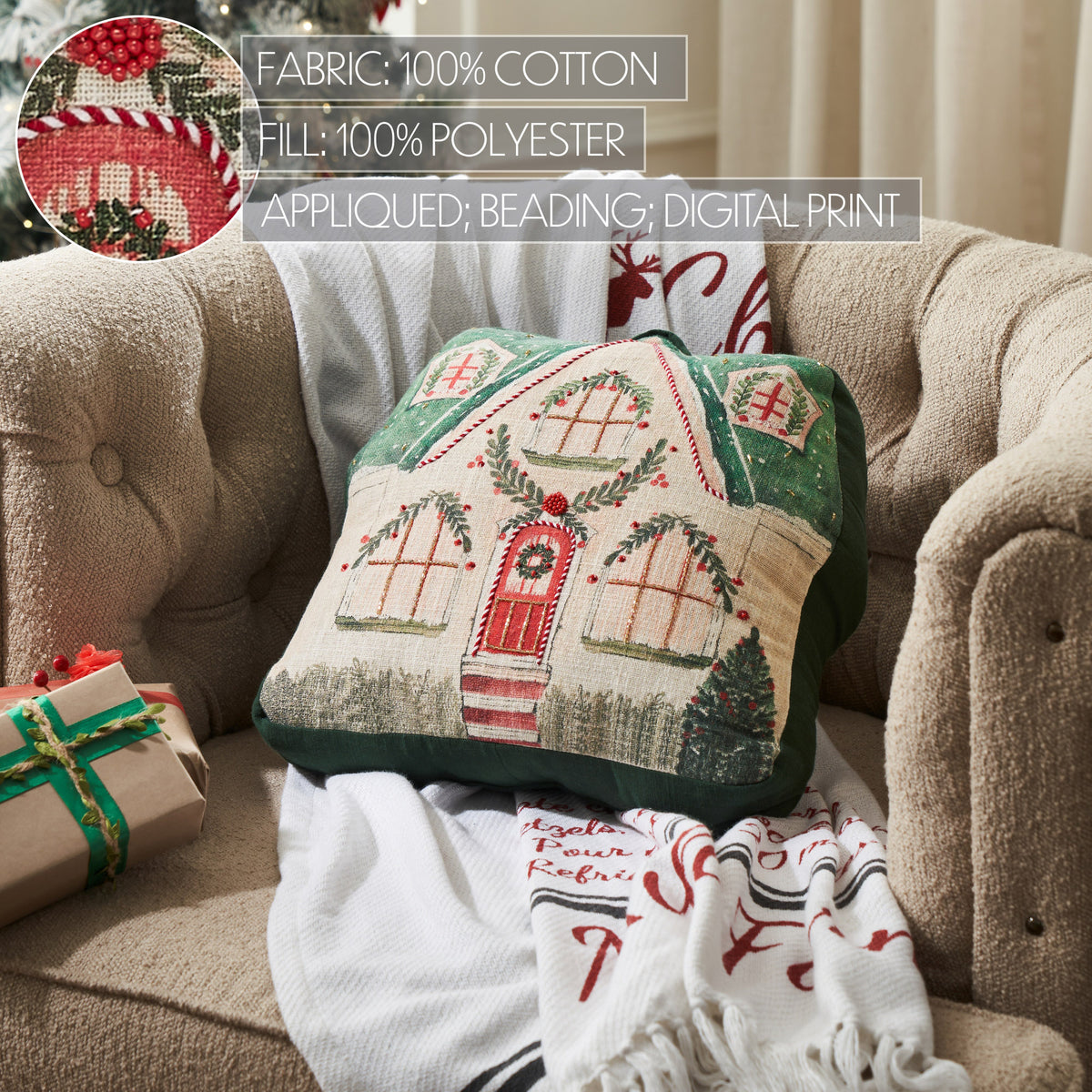 Close-up living room shot highlighting the fabric texture and embroidered stitching of the gingerbread house pillow.